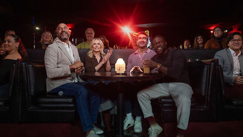 Keegan-Michael Key, Chelsea Handler, Kumail Nanjiani, dan Kevin Hart duduk di meja bundar di klub atau ruang komedi yang remang-remang, tersenyum dan menonton pertunjukan, dengan lilin menyala di atas meja dan penonton di latar belakang.
