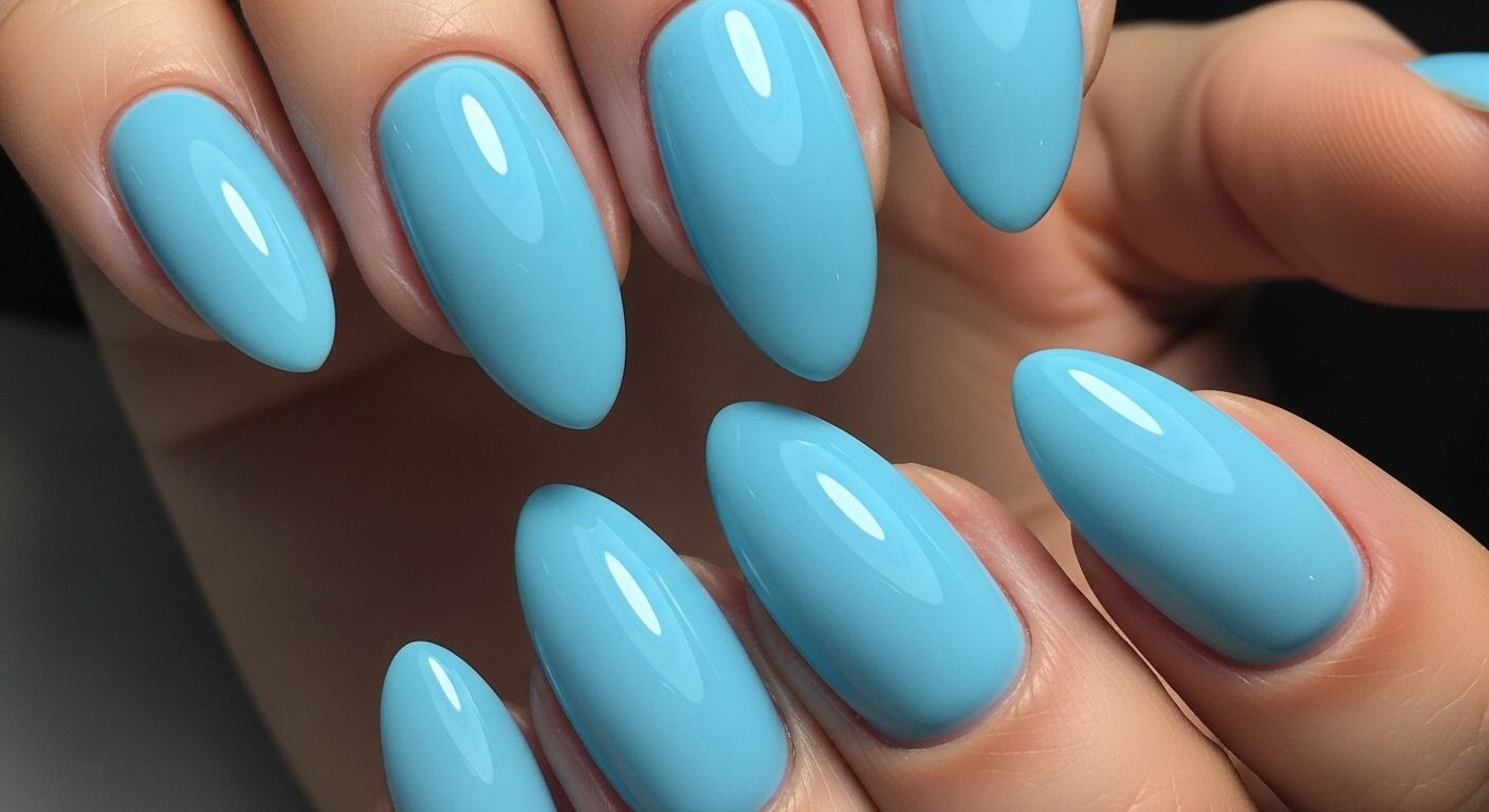 Tampilan jarak dekat dari tangan dengan kuku terawat berbentuk almond biru langit mengkilap