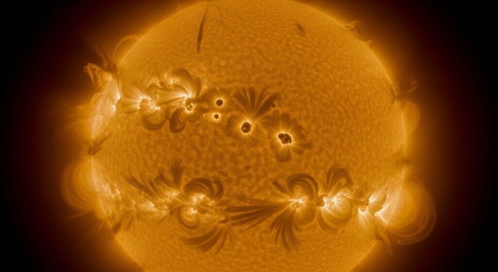 Matahari menunjukkan bintik matahari aktif dan jilatan api matahari dalam gambar ultraviolet yang mendetail.