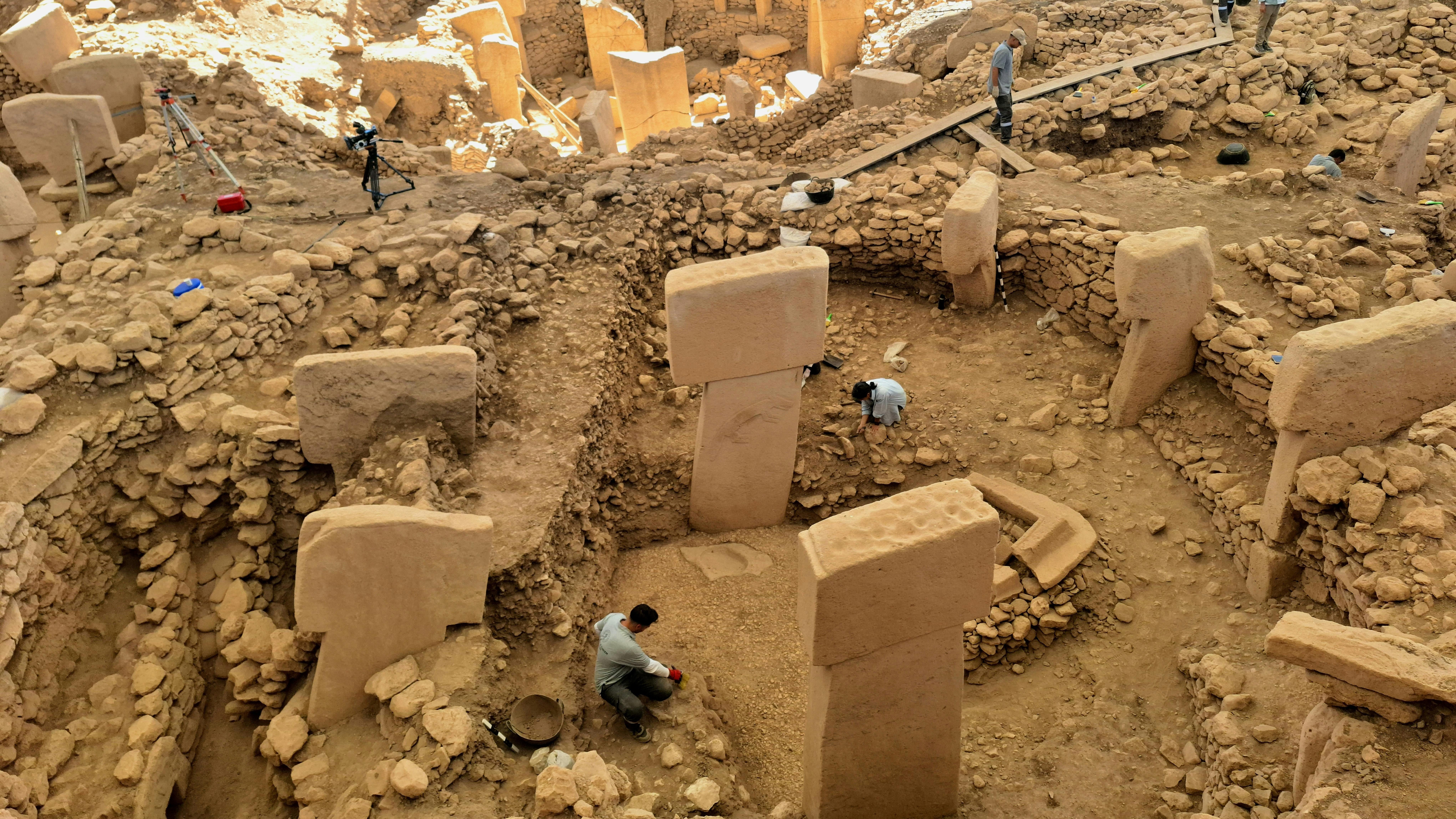 Para arkeolog menggali pilar batu kuno di situs arkeologi Göbekli Tepe di Turki.