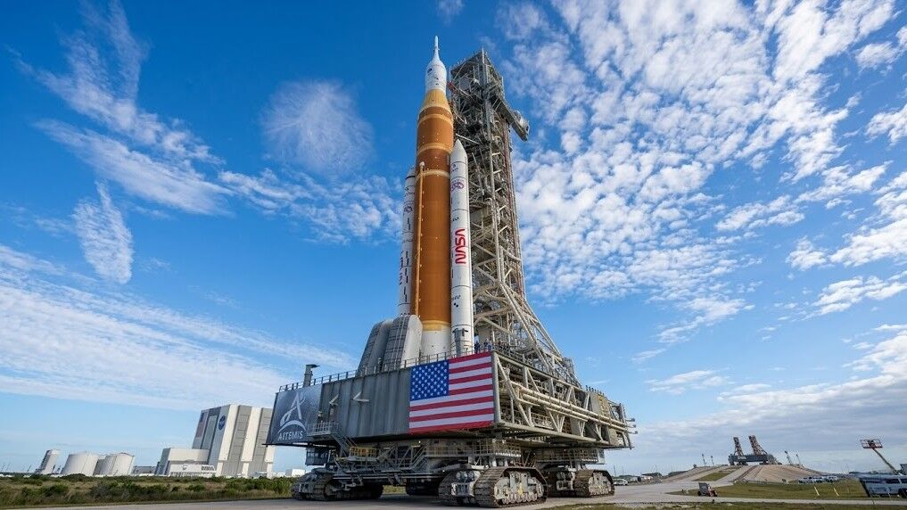 Roket NASA Artemis pada platform peluncuran seluler di Kennedy Space Center di bawah langit biru