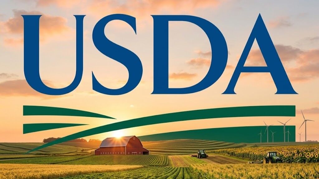Logo USDA di atas pemandangan matahari terbenam di ladang pertanian dengan gudang merah, traktor, dan turbin angin.