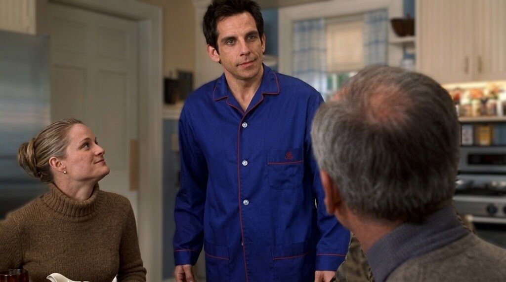 Ben Stiller dengan piyama biru berbicara dengan dua orang di dapur