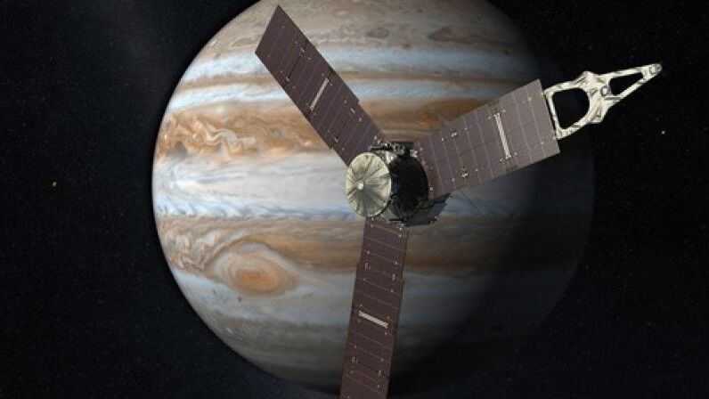 Pesawat ruang angkasa Juno NASA mengorbit Jupiter dengan panel surya memanjang dengan latar belakang bintang.