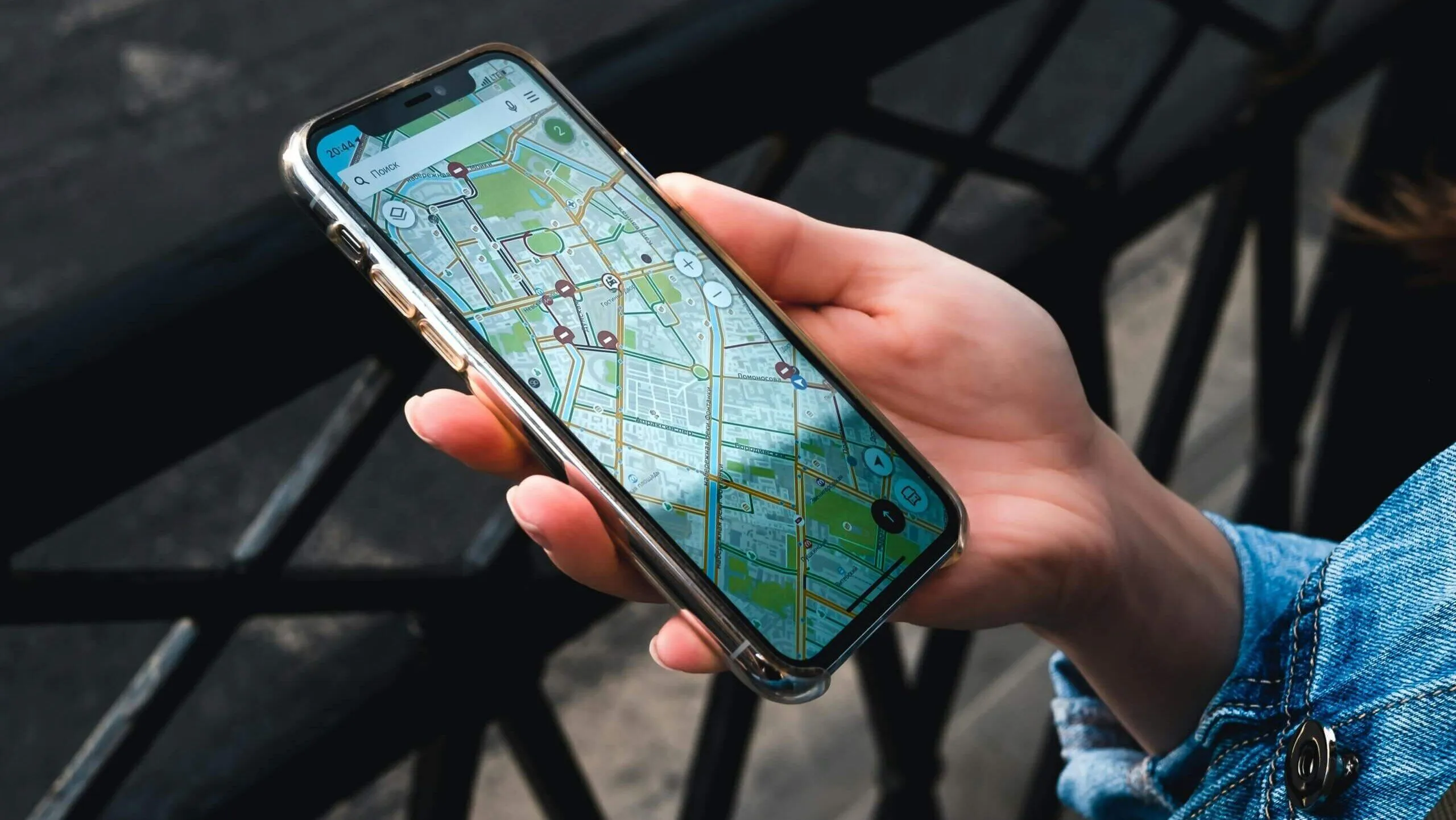 Ponsel pintar genggam menampilkan peta kota terperinci dengan rute navigasi dan tempat menarik.