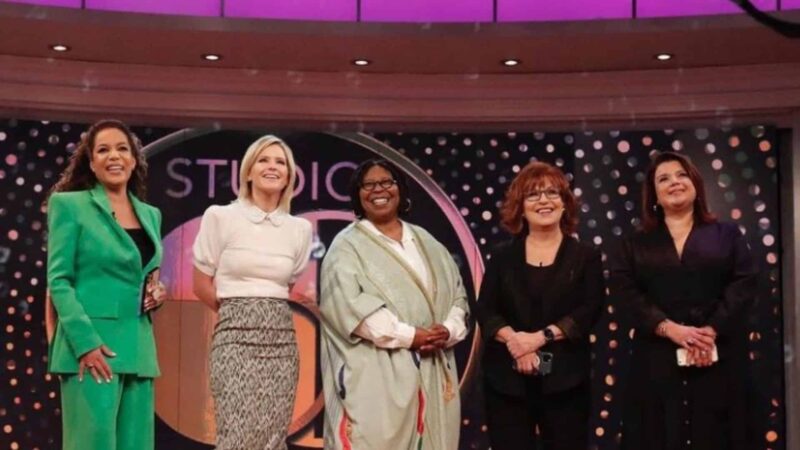 Five women smiling on the set of Studio 5, wearing professional and casual attire