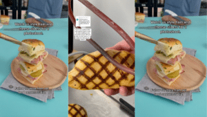 Hand holding grilled sandwich bun with crosshatch marks, and stacked ham and cheese sliders on a wooden plate.