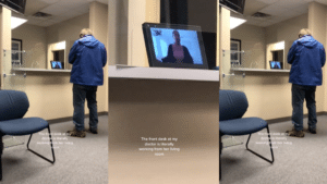 Man standing at a medical office front desk with a video call screen showing a woman working remotely from her living room