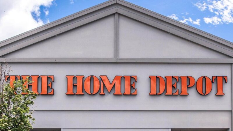 The Home Depot store sign on a gray building facade with a blue sky background