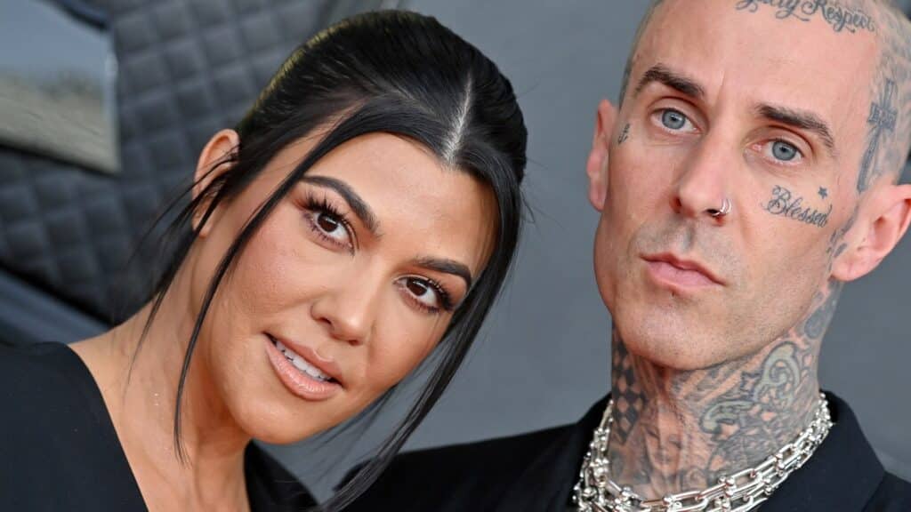 Kourtney Kardashian and Travis Barker posing together at an event