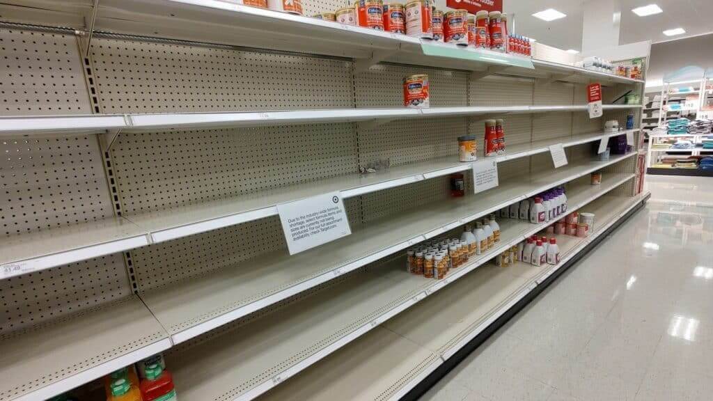 Mostly empty store shelves with limited Enfamil toddler formula and other baby products remaining