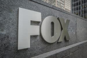 Metallic FOX logo mounted on a gray stone wall outside an office building