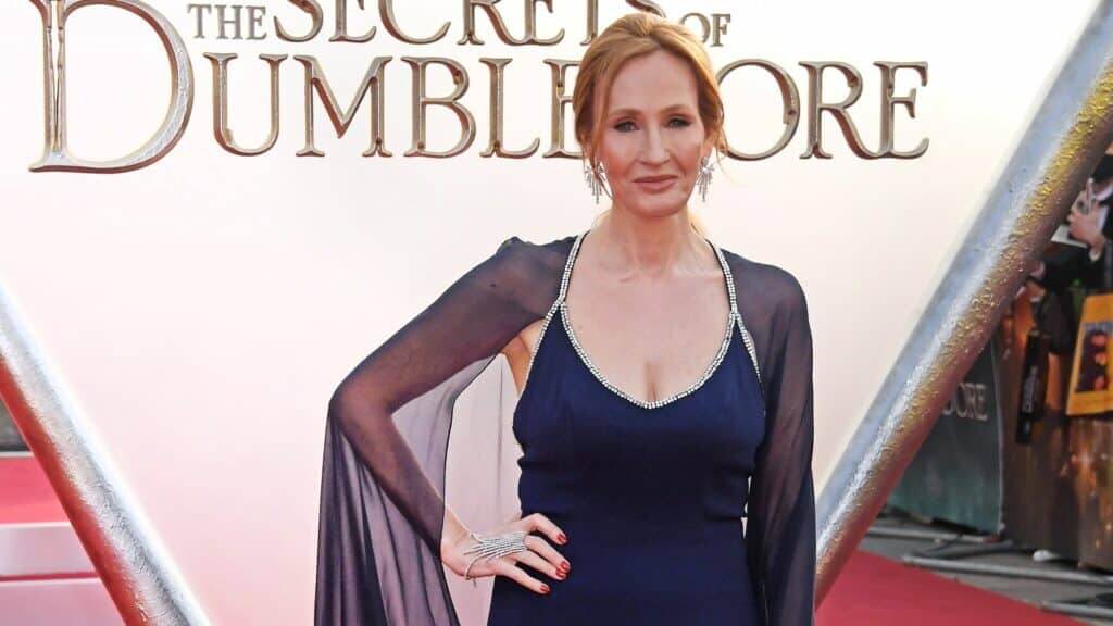 J.K. Rowling wearing a navy blue dress with sheer sleeves at The Secrets of Dumbledore premiere.