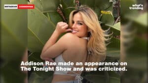 Addison Rae smiling over her shoulder wearing a white halter top with large green leaves in the background