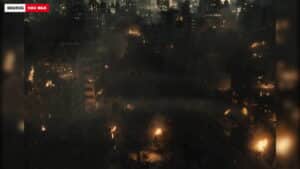Nighttime cityscape with multiple buildings on fire and smoke rising, from HBO Max footage.