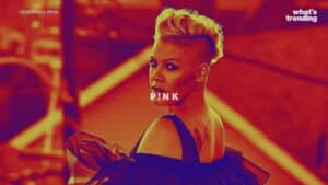 Singer Pink with a blonde mohawk hairstyle and black off-shoulder dress looking over her shoulder