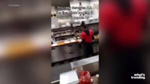 Woman in red shirt cooking multiple plates in a commercial kitchen, preparing food for 12 people alone