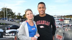 Two people smiling, one wearing a blue shirt labeled "AMY," the other wearing a black Arkansas sweatshirt.