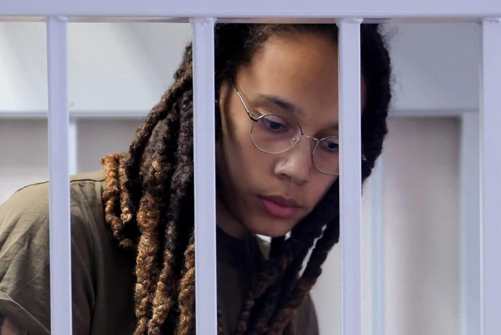 US basketball player Brittney Griner stands in a defendants' cage before a court hearing during her trial on charges of drug smuggling, in Khimki, outside Moscow on August 2, 2022. - Griner was detained at Moscow's Sheremetyevo airport in February 2022 just days before Moscow launched its offensive in Ukraine. She was charged with drug smuggling for possessing vape cartridges with cannabis oil. Speaking at the trial on July 27, Griner said she still did not know how the cartridges ended up in her bag.