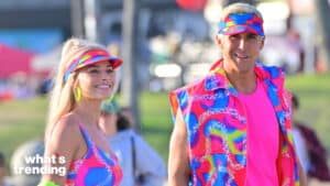 Two people smiling and wearing colorful neon pink, blue, and yellow outfits with matching visors outdoors