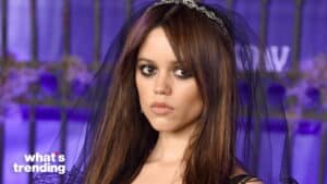 Maya Hawke wearing a black veil and smoky eye makeup at a purple-lit event backdrop