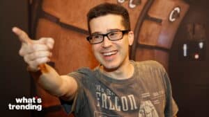 Man wearing glasses and a Star Wars Falcon t-shirt pointing and smiling against a sci-fi background