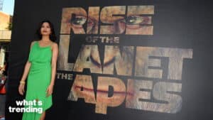 Freida Pinto in a green dress posing at the Rise of the Planet of the Apes premiere backdrop