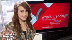 Shira Lazar smiling in front of a screen displaying "what's trending" and Samsung Hope for Children branding