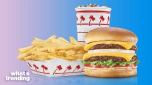 In-N-Out double cheeseburger with lettuce, tomato, onions, fries, and a soda cup on a blue background