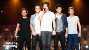 One Direction performing on stage with Harry Styles singing into a microphone.