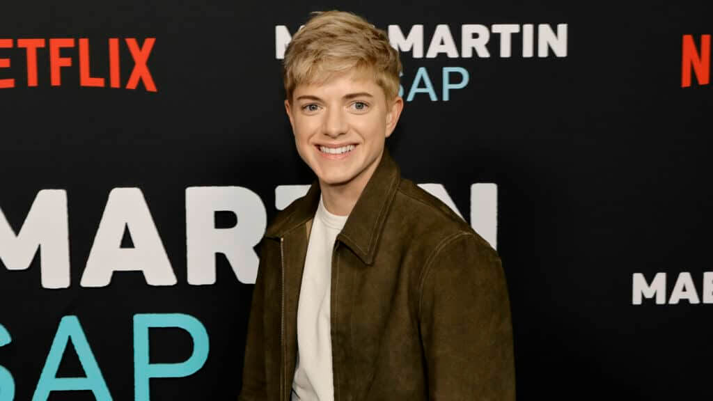 Actor Lucas Hedges smiling at the Martin SAP Netflix event backdrop
