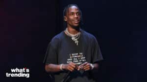 Travis Scott wearing an Astroworld T-shirt and holding a microphone on stage