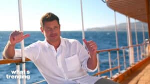 Man in white shirt giving thumbs up on a boat with ocean background and "what's trending" text