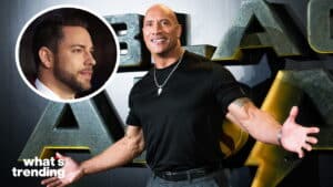 Dwayne Johnson smiling with arms open at a Jumanji event, inset of Zachary Levi in profile with "what's trending" text.