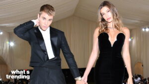 Justin Bieber and Hailey Bieber holding hands at a formal event, dressed in black evening wear.