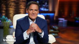 Mark Cuban sitting in a white chair wearing a blue suit on the set of "What's Trending"