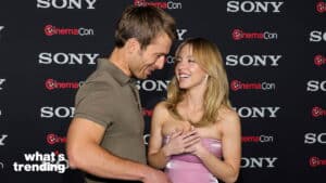 Two people smiling and talking at a Sony CinemaCon event with branded backdrop