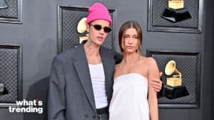 Justin Bieber wearing a pink beanie and sunglasses with Hailey Bieber in a white strapless dress at the Grammy Awards.
