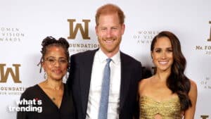Prince Harry and Meghan Markle pose with a woman at the Women of Vision Awards event.