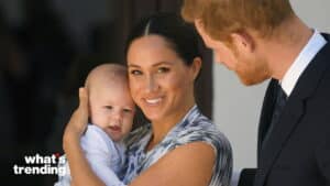 Meghan Markle holding baby Archie while Prince Harry looks on, smiling