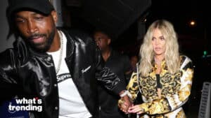 Khloé Kardashian holding hands with a man wearing a black Supreme jacket at night