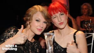 Taylor Swift and Hayley Williams smiling and giving thumbs up, Hayley holding a trophy at an event.
