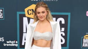 Kelsea Ballerini wearing a white embellished crop top and blazer at the CMT Music Awards red carpet