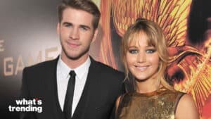 Liam Hemsworth and Jennifer Lawrence smiling at a red carpet event for The Hunger Games.