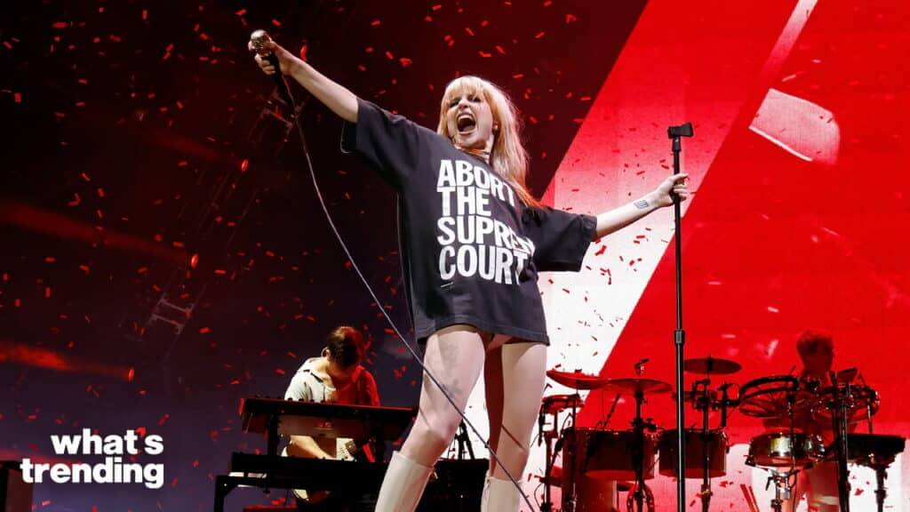 Singer Hayley Williams performing on stage wearing a black shirt with "ABORT THE SUPREME COURT" text