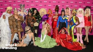 Group of drag performers in colorful, extravagant outfits posing on a RuPaul's Drag Race event red carpet.