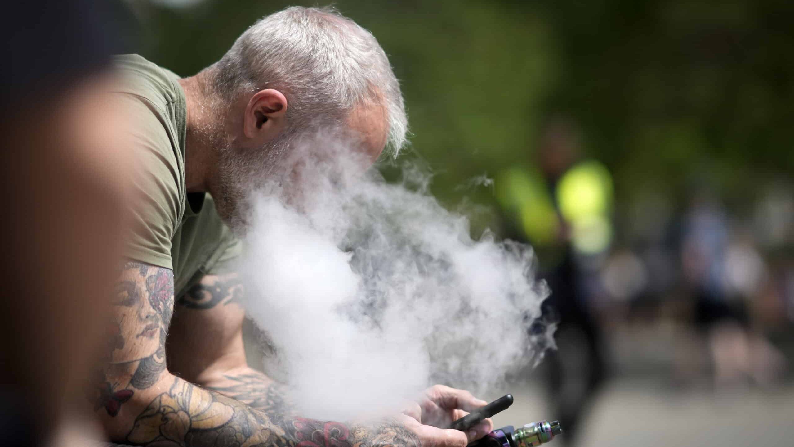 MANCHESTER, ENGLAND - MAY 30: A man smokes a vape device on May 30, 2023 in Manchester, England. The British prime minister has tried to cast a harsh light on "unacceptable" marketing of vaping products to teenagers and children, saying his government would close a loophole that allows retailers to give free vape samples to children.