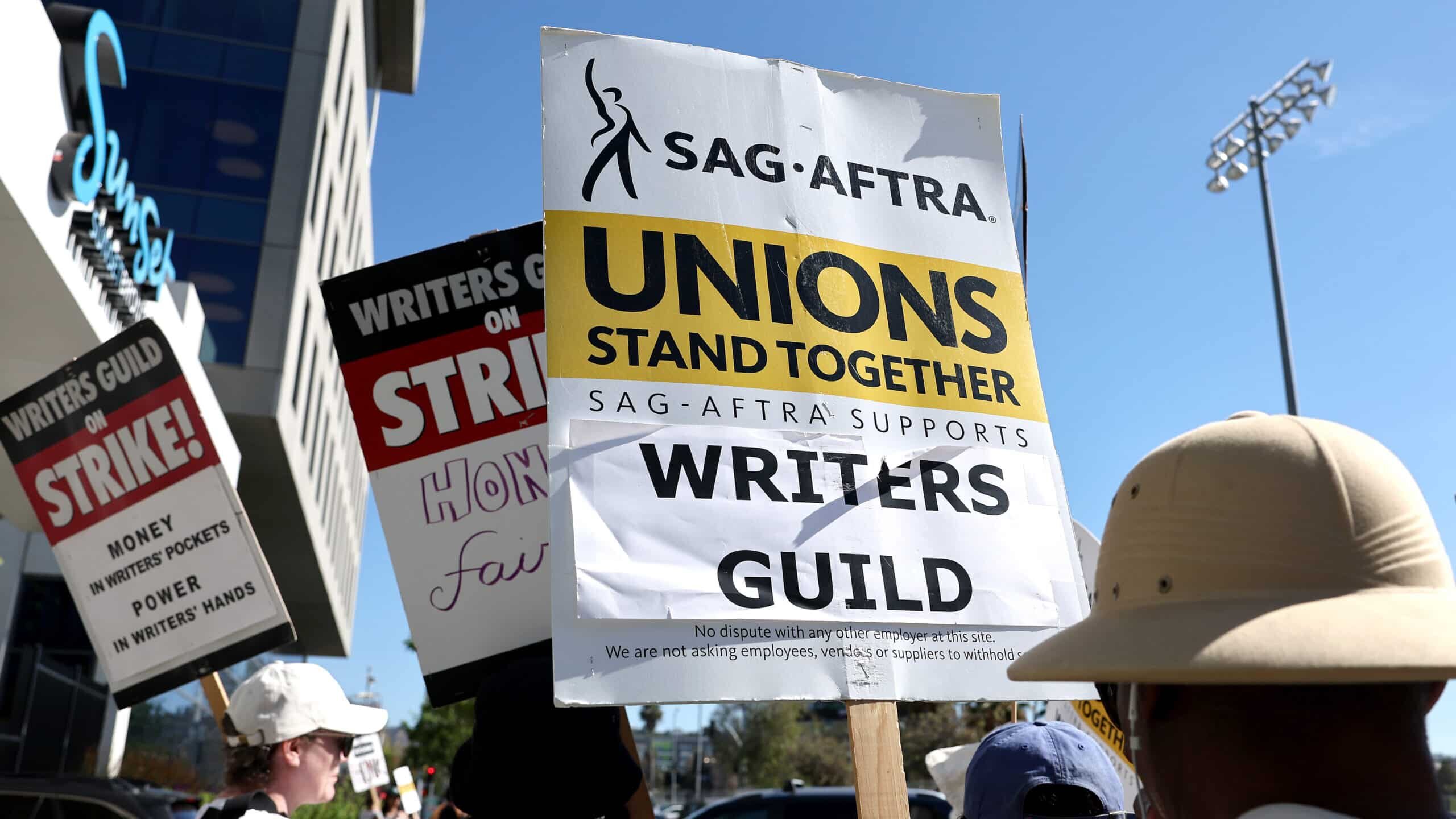 LOS ANGELES, CALIFORNIA - JULY 13: A sign reads 'Unions Stand Together' as SAG-AFTRA members walk the picket line in solidarity with striking WGA (Writers Guild of America) workers outside Netflix offices on July 13, 2023 in Los Angeles, California. Members of SAG-AFTRA, Hollywood’s largest union which represents actors and other media professionals, will likely go on strike after a midnight deadline over contract negotiations with studios expired. The strike could shut down Hollywood productions completely with writers in the third month of their strike against Hollywood studios.