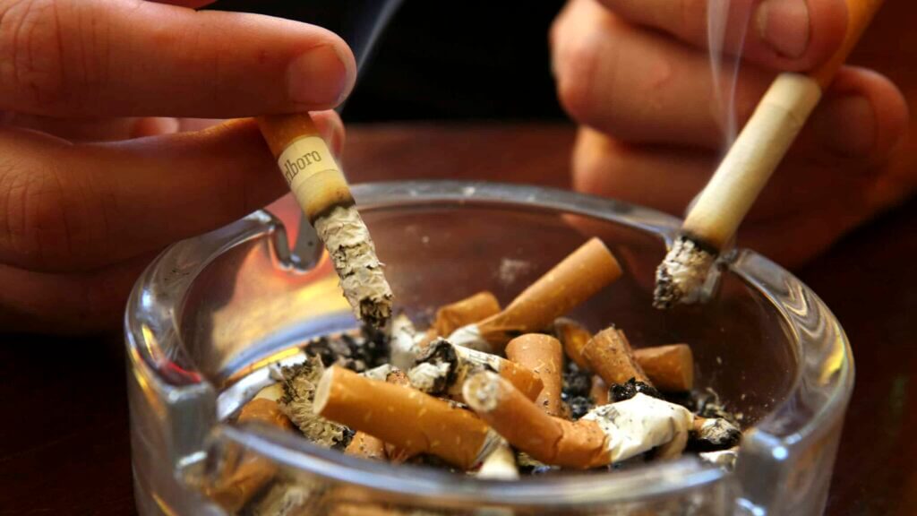 BATH, UNITED KINGDOM - JUNE 30: A couple smoke cigarettes in a public house in Bath, on June 30 2007 in Somerset, England. From 6am July 1 smoking in all enclosed places such as cafes and pubs will be banned.