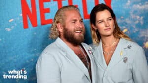 Two people wearing light blue blazers posing in front of a Netflix backdrop at an event.